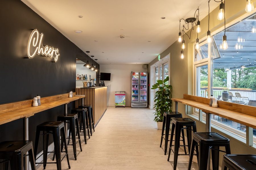 Fish Bar Cornwall interior with neon Cheers sign, counter and bar seating